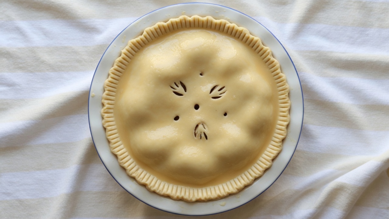 Unbaked double-crust apple pie with vents and egg wash