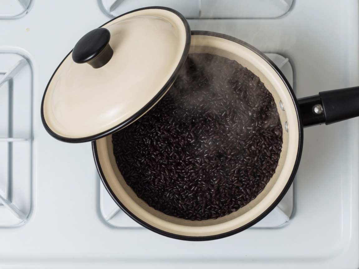 Cooked black rice in the same cream enamel saucepan with the lid ajar